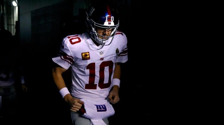 The Giants' Eli Manning runs onto the field