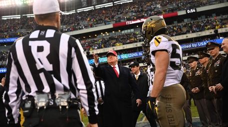 President Donald Trump tosses the coin before the