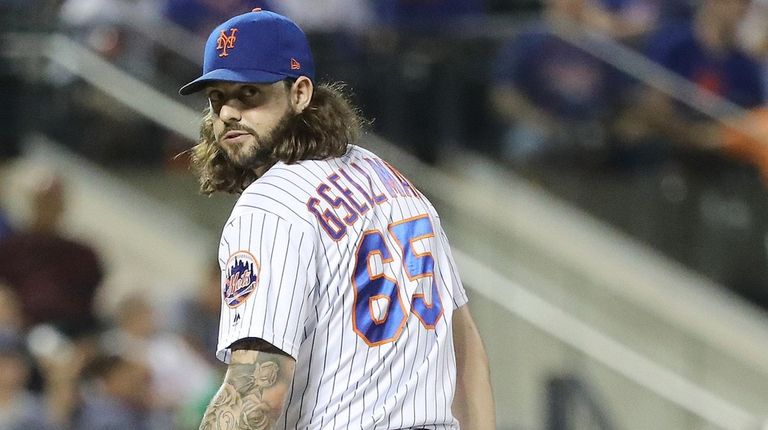 Mets relief pitcher Robert Gsellman checks the runner