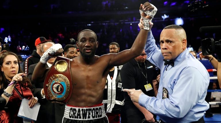 Terence Crawford has his hand raised in victory