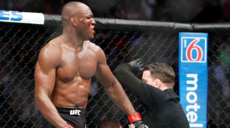 Kamaru Usman stands up after defeating Colby Covington