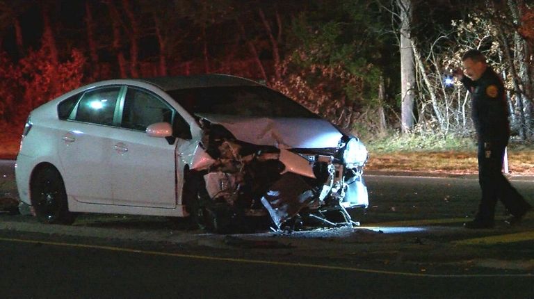 A Suffolk County police officer examines a vehicle