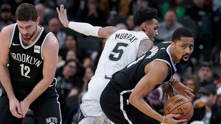 Nets' Spencer Dinwiddie, right, gets away from San