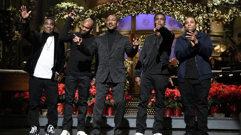 Eddie Murphy, center, is flanked by fellow comedians