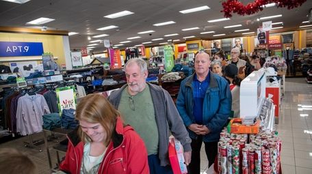 Last-minute shoppers wait in line Monday at a