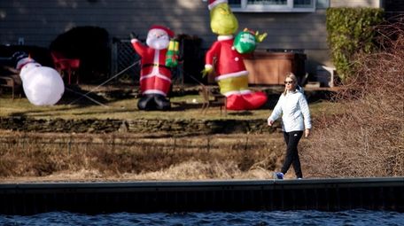 Against a backdrop of Christmas decorations, a woman