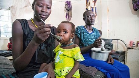 A mother gives food to her child with