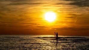 Long Beach resident Brendan McDerby paddle boarding off