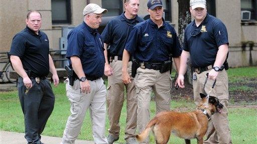 Officers with a dog after searching Evangeline Hall