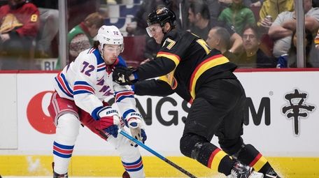 Vancouver Canucks' Tyler Myers, right, checks Rangers' Filip