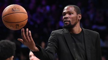 Nets forward Kevin Durant tosses the ball during