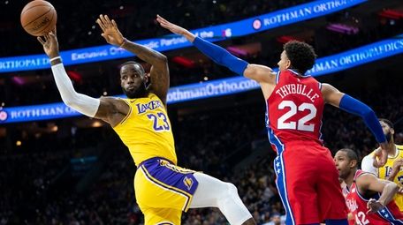 Los Angeles Lakers' LeBron James, left, passes the