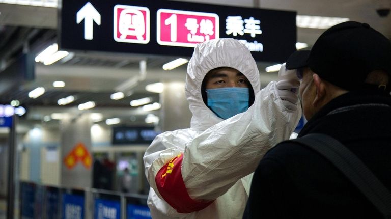 A health worker checks the temperature of a