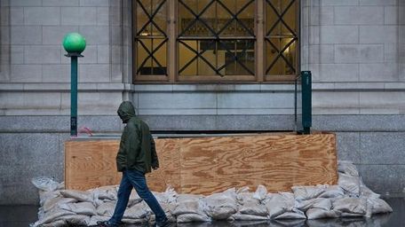 A man walks past a barricaded subway entrance