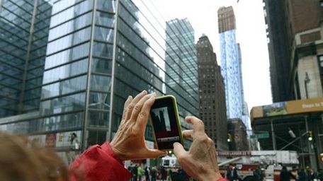 Tourists flock to the crane dangling on West