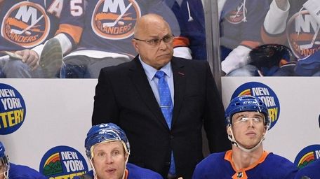 Islanders head coach Barry Trotz, center, looks on