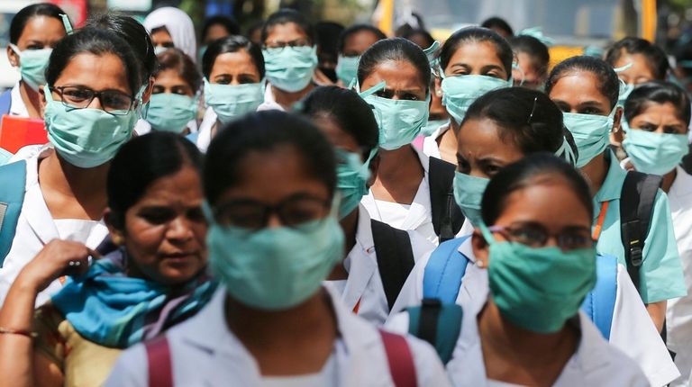 Indian nursing students wearing masks walk in a