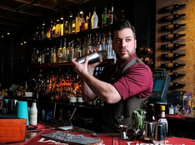 Head Bartender Matthew Zeiss shakes a cocktail from