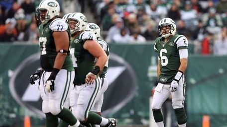 Mark Sanchez #6 and teammates walk of field.