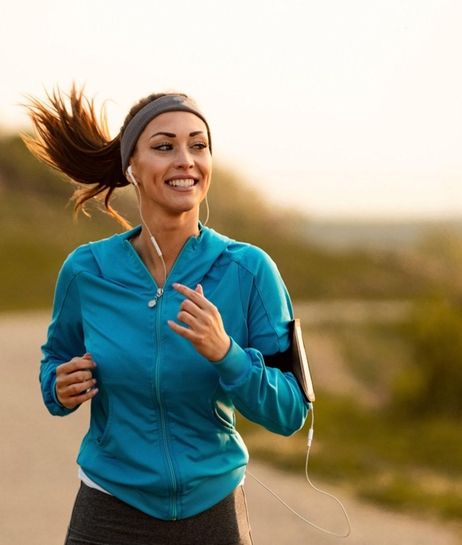 Dedicated athletic woman running in nature and dawn.