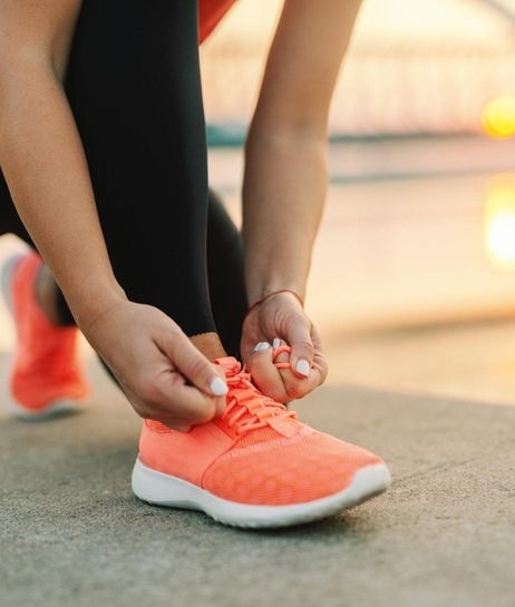 Close up of sporty woman tying shoelace while
