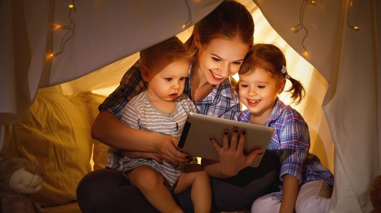 Mother and children playing games on a tablet.