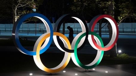 A man is seen through the Olympic rings
