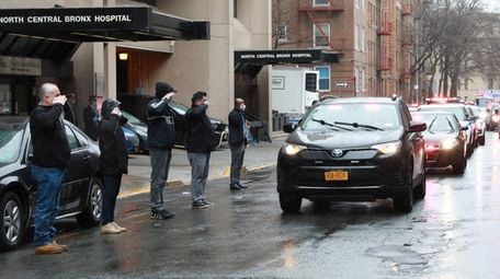 Officers salute as a motorcade carrying the body