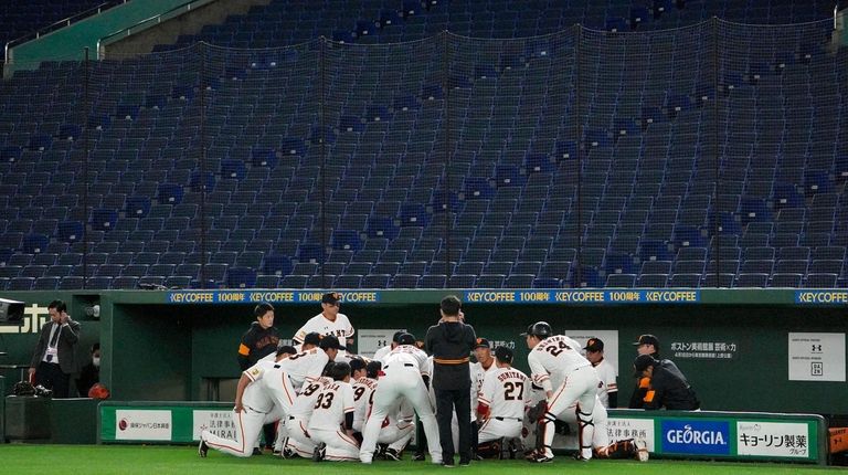 Members of Yomiuri Giants huddle ahead of a
