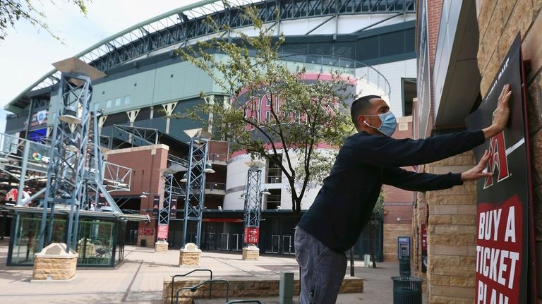 Joey Rodriguez, of Image Craft, installs an advertising
