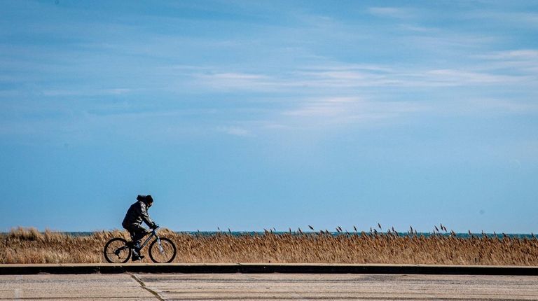 A man rides a bike along the walkway