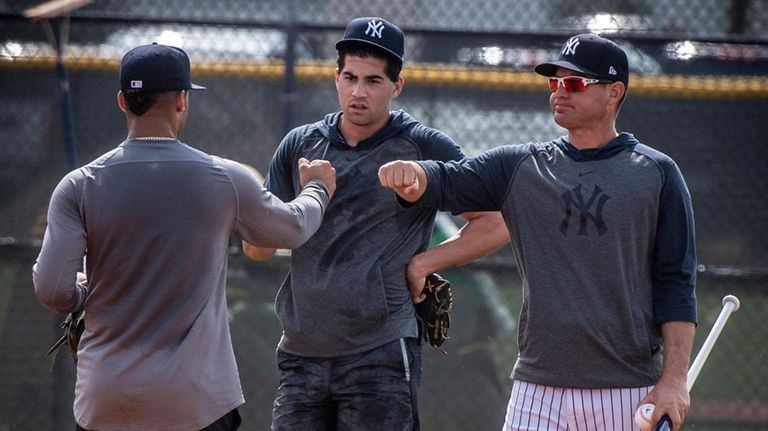Yankees infield coach Carlos Mendoza, right, talks with