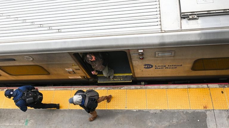 Commuters walk from a train at the Ronkonkoma