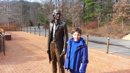 Harrison Kellogg McKenna stands alongside a statue of
