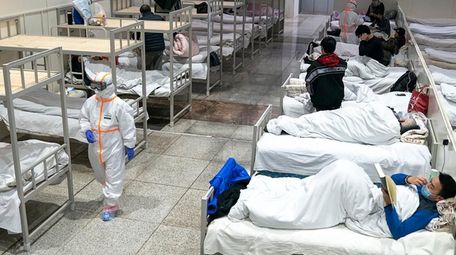 A medical worker in a protective suit walks