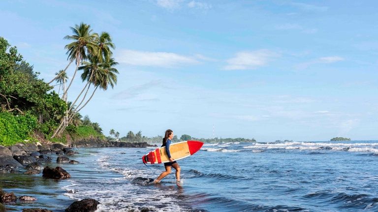 A surfer prepares to ride waves at the