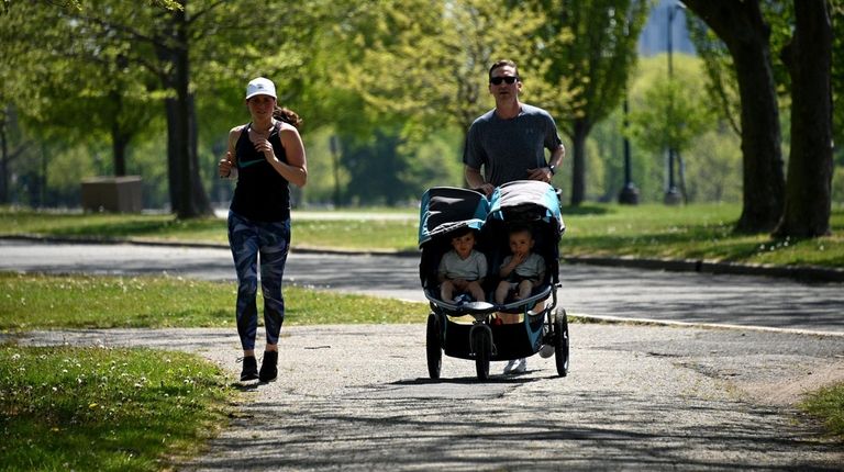 A family jogs together on a summerlike day