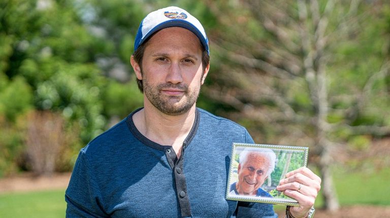 Tyler Gildin holds a photo of his late