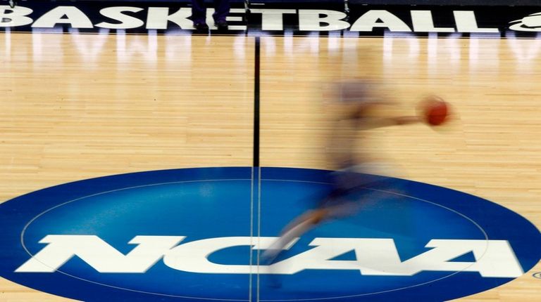 A player runs across the NCAA logo during