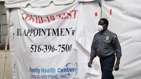 A security guard walks near the COVID-19 testing