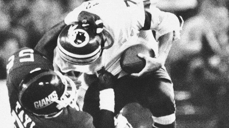 Washington Redskins quarterback Joe Theismann is brought down
