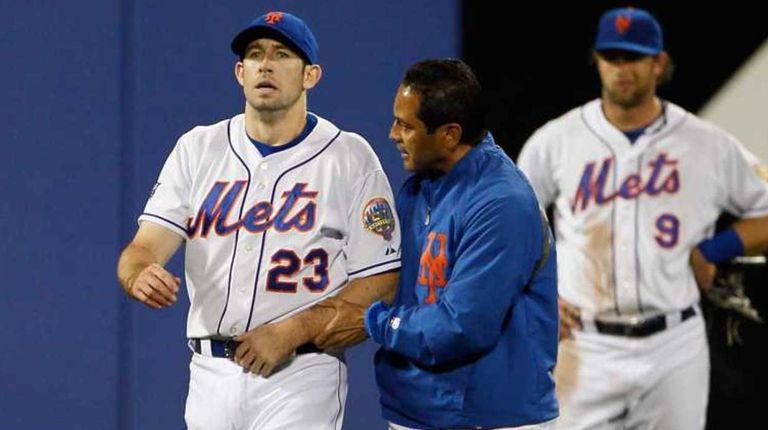 Mets head trainer Ray Ramirez walks Mike Baxter