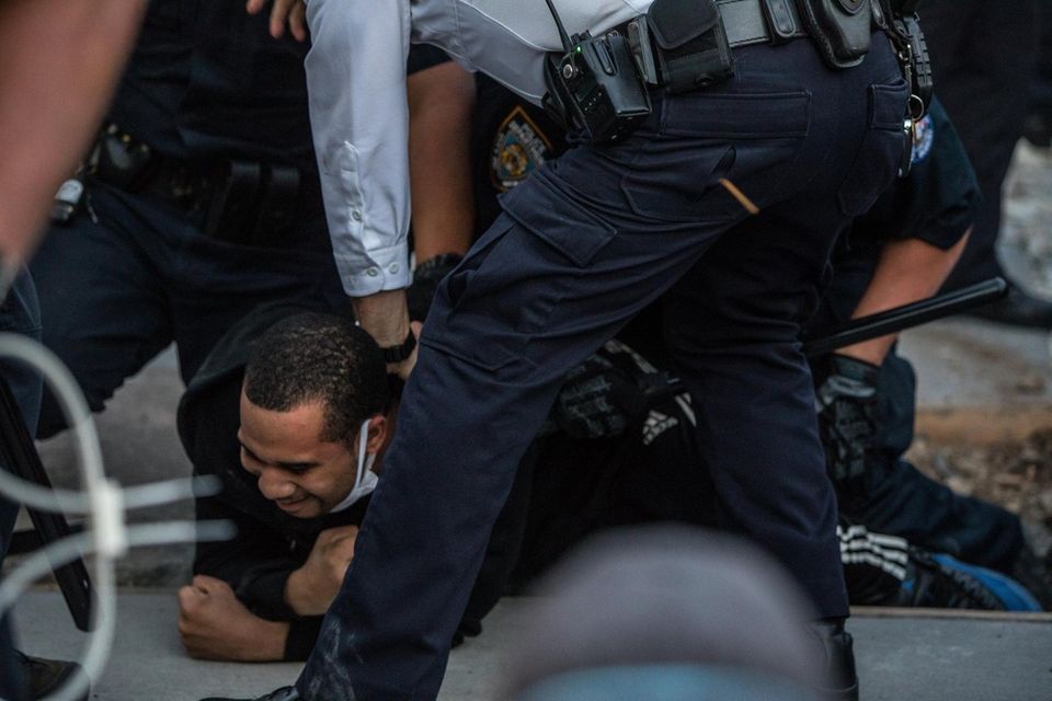 A man is detained during continuing protests stemming