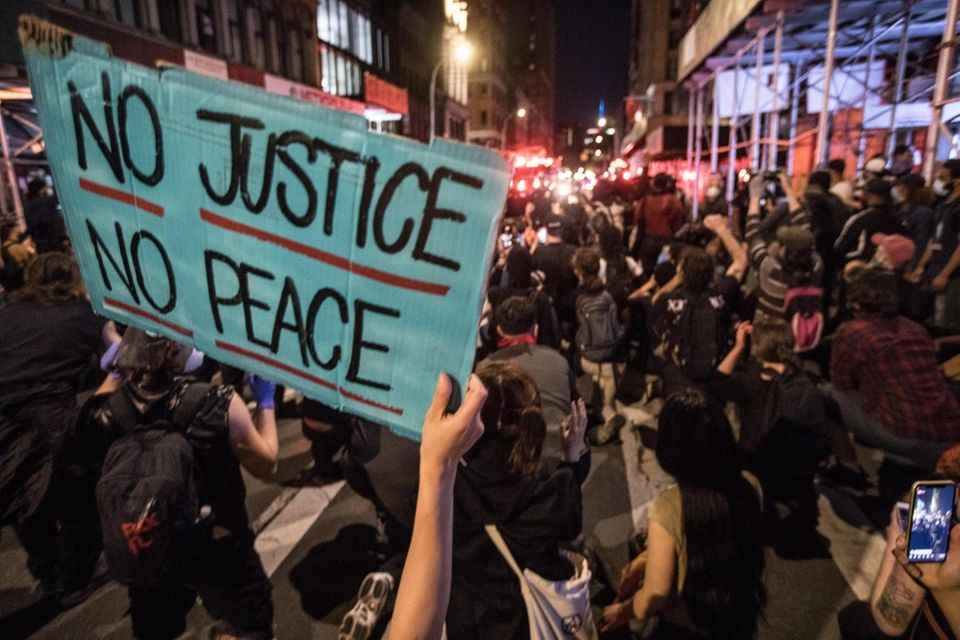 A sign reading "no justice no peace" during