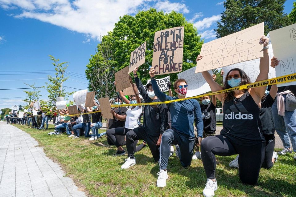 Hundreds of demonstrators take a knee demanding justice