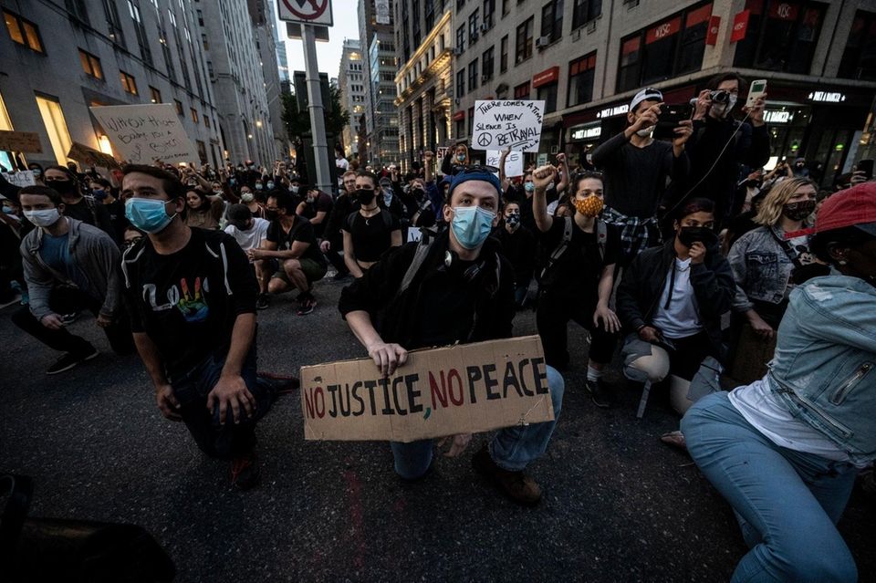 People hold signs during a march to protest
