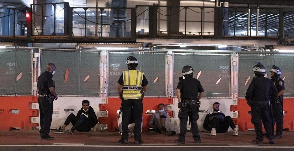 Members of the NYPD apprehend people on 5th