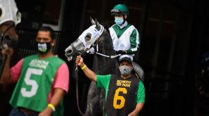 Jockeys ride out on their horses during the