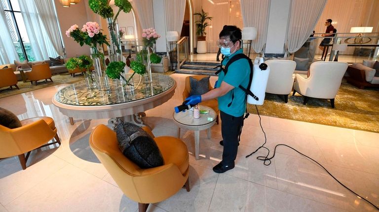 A mask-and-glove-clad cleaning staff member of the Jumeirah