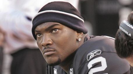 Oakland Raiders quarterback JaMarcus Russell sits on the